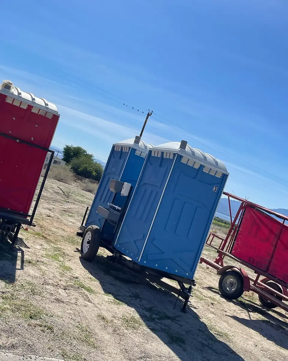 Porta potties strapped to a delivery trailer ready for a route