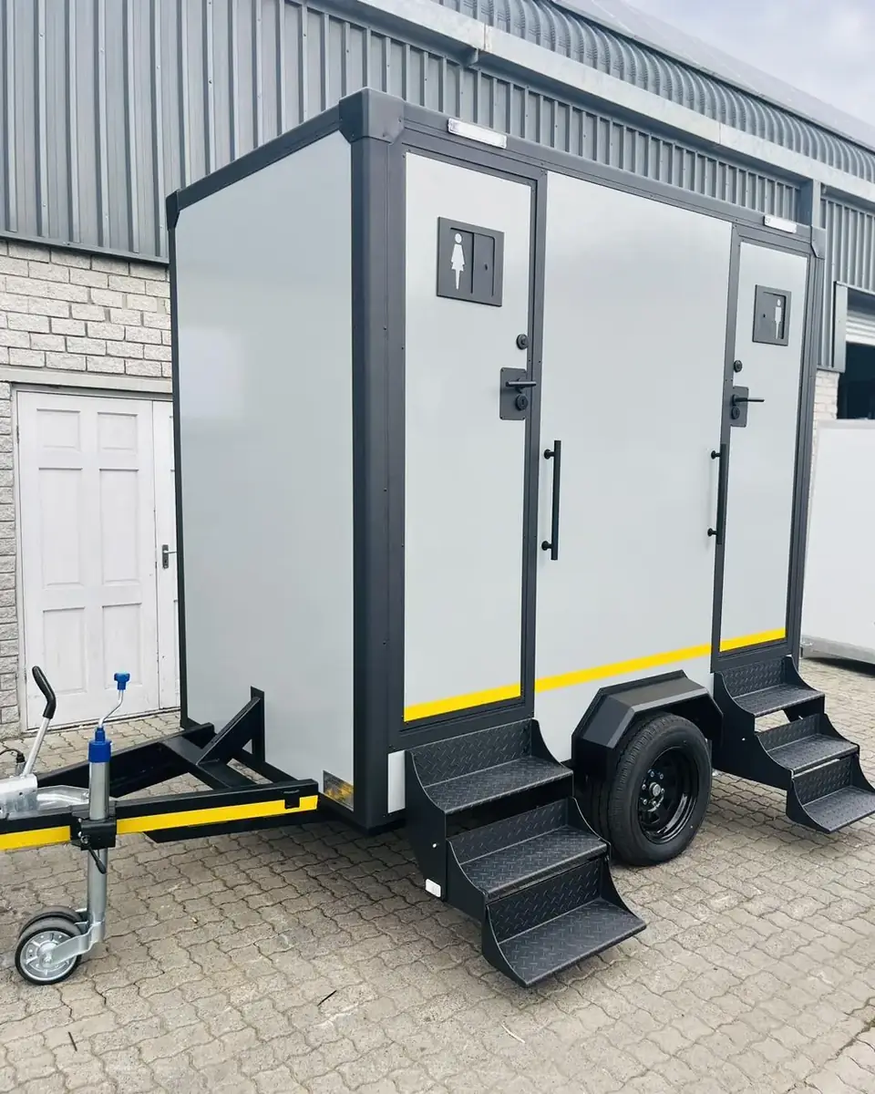 Two-stall white restroom trailer with fold-down steps